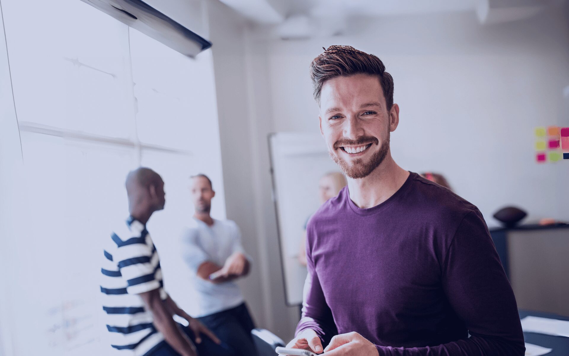 man smiling in a team meeting