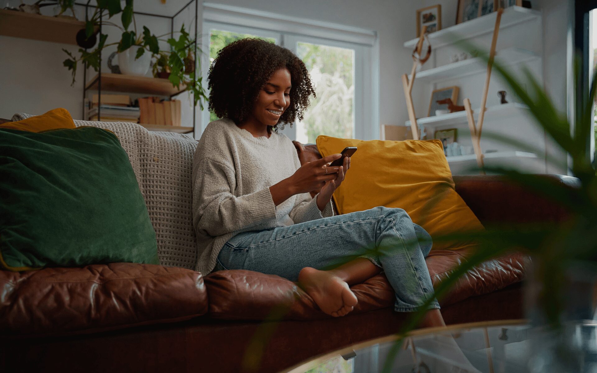 woman sitting on a sofa looking at her phone