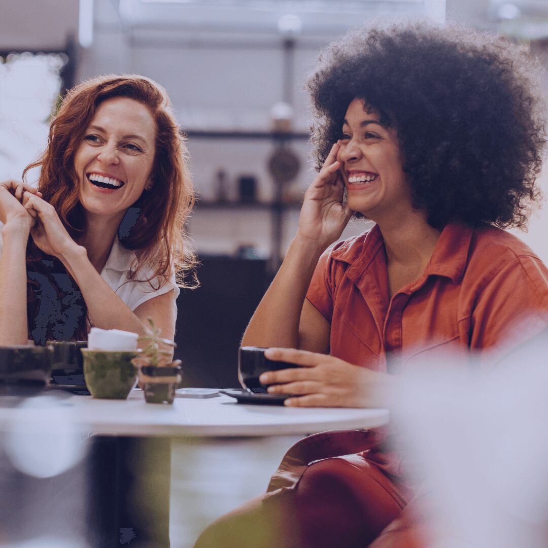 two women having a coffee and smiling