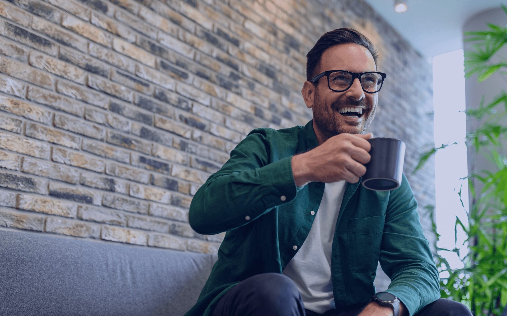 man laughing while having a coffee