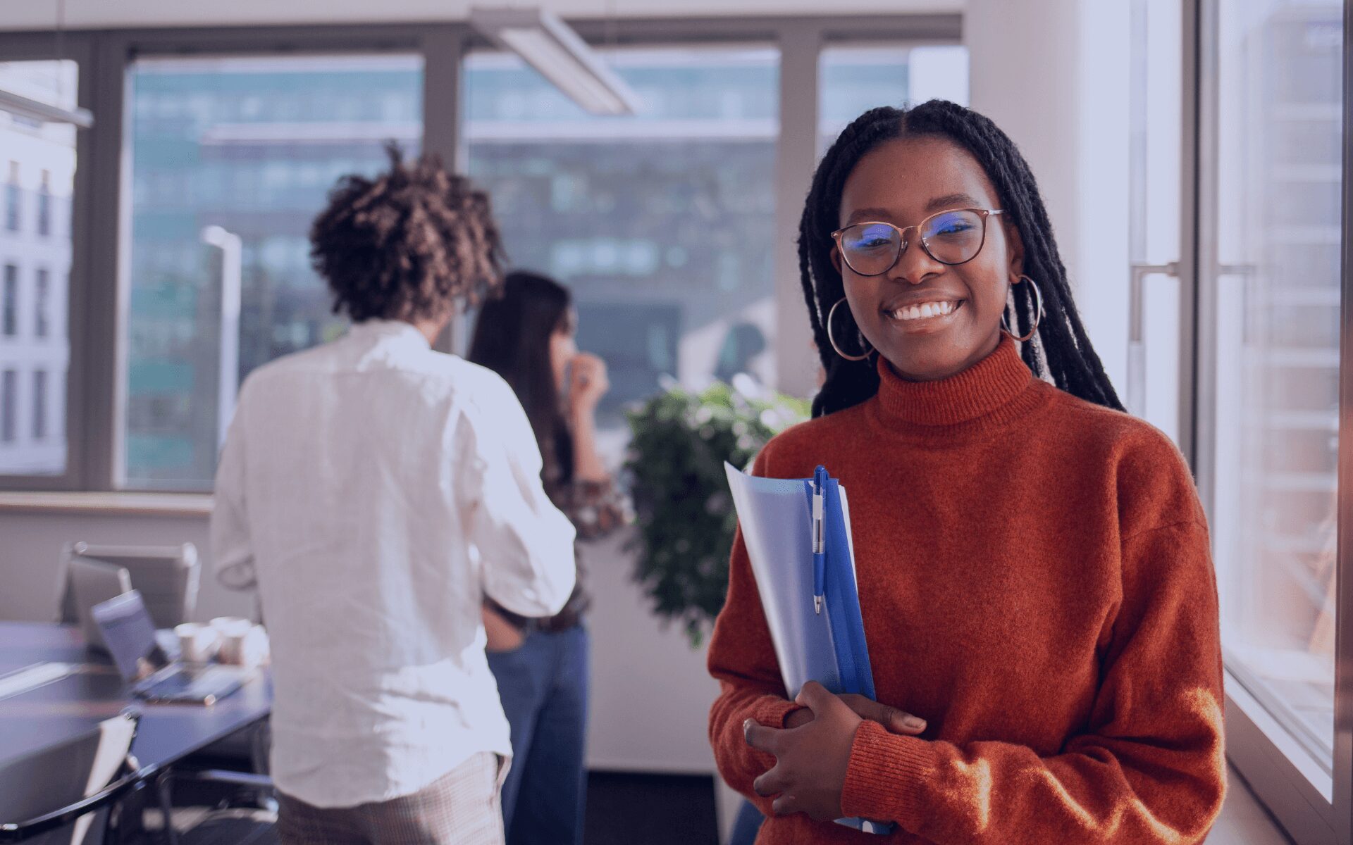 woman smiling with co workers in the background